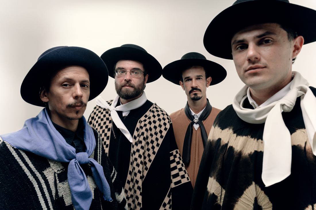 Os 4 integrantes de poncho e chapéu